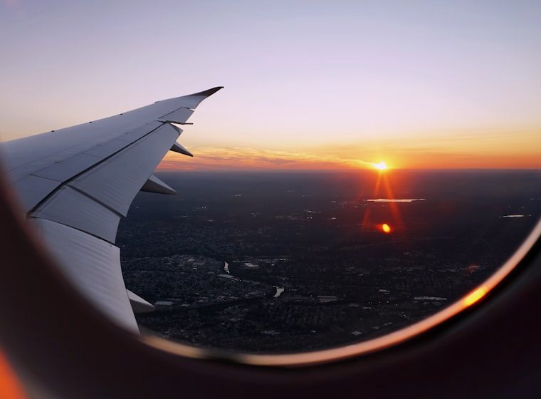 Looking out of an airplane window at sunset